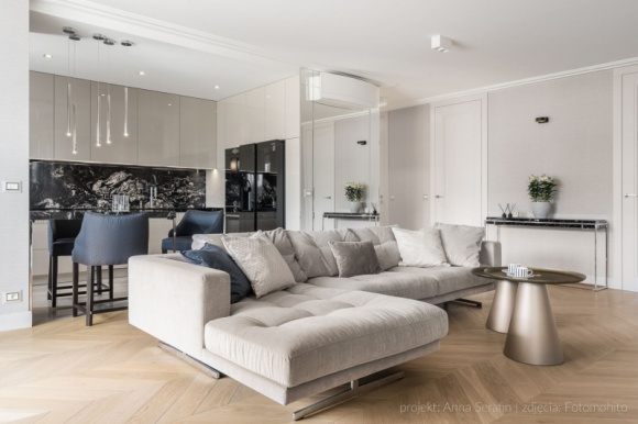  Dom, LIFESTYLE - Położony w centrum Gdyni apartament urządzony został w jasnej kolorystyce przypominającej piaszczyste plaże, ale też sztandarowe barwy modernizmu. Złamane biele, ciepłe beże i szarości tworzą eleganckie tło, na którym efektownie prezentuje się starannie dobrane wyposażenie.